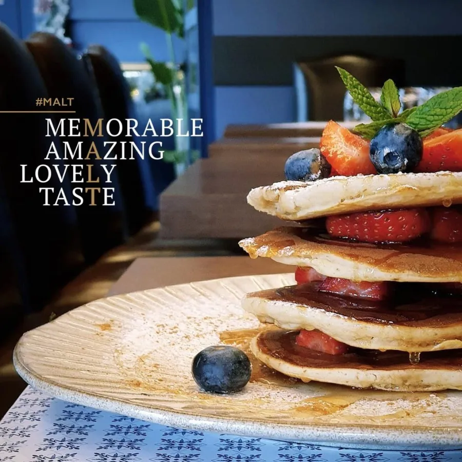 Stacked pancakes with fresh berries and mint
